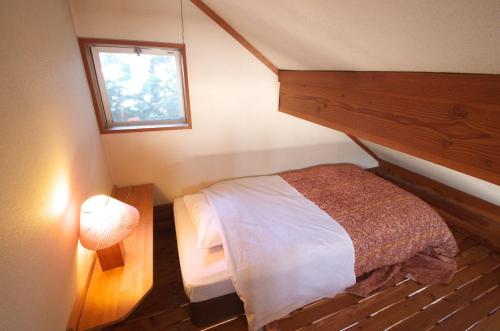 a small bedroom with a bed and a window at Cottage&Pension Love Thirty in Karuizawa
