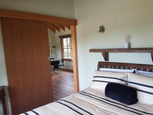 a bedroom with a bed and a door leading into a room at Inverloch par 3 Golf & Cafe and Cocoa & Briar Cottages in Inverloch