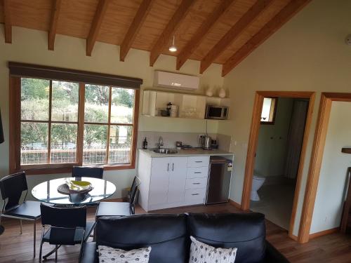 a kitchen and living room with a table and chairs at Inverloch par 3 Golf & Cafe and Cocoa & Briar Cottages in Inverloch