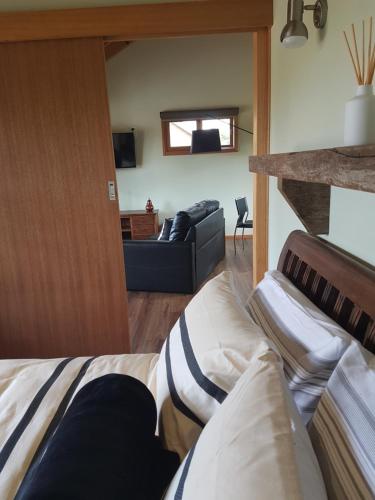 a living room with a bed and a couch at Inverloch par 3 Golf & Cafe and Cocoa & Briar Cottages in Inverloch