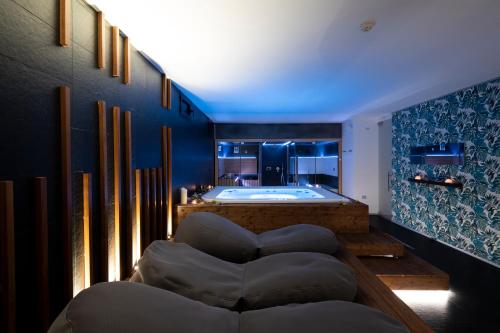 ein Bad mit Badewanne und Sofa und ein Zimmer mit Badewanne in der Unterkunft Alkamuri Posh Hotel e Spa in Alcamo