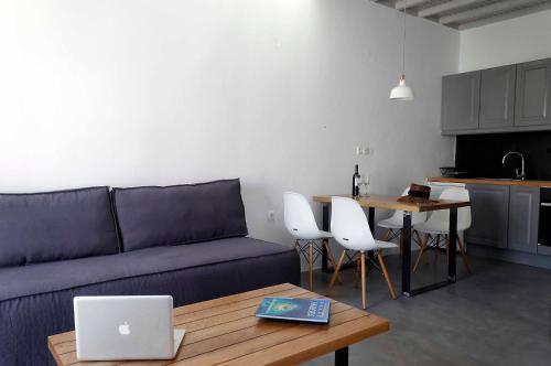 a living room with a couch and a table with a laptop at Mykonos Loft in Mikonos