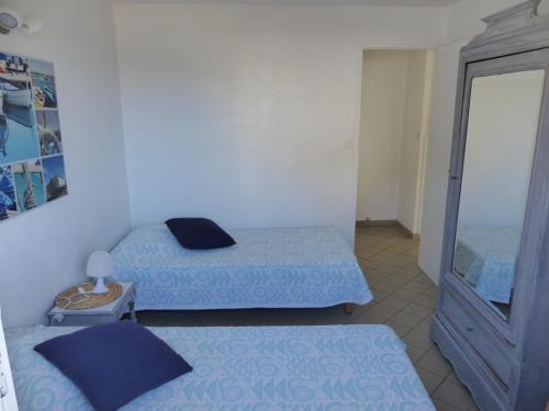 Habitación con 2 camas y espejo. en Appartement Pour 4 Personnes Dans Villa Dans Le Vent en Hossegor