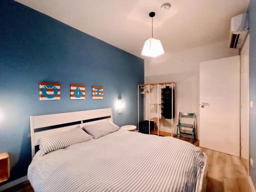 een slaapkamer met een groot bed met een blauwe muur bij Mandracchio Central Apartment in Grado