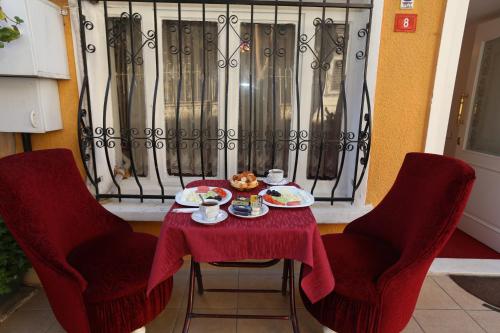 een tafel met twee stoelen en een bord eten erop bij Masal Hotel in Buyukada
