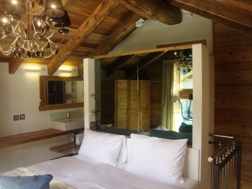 a bedroom with a bed with a mirror and a chandelier at Hotel Hemizeus & Iremia Spa in Zermatt