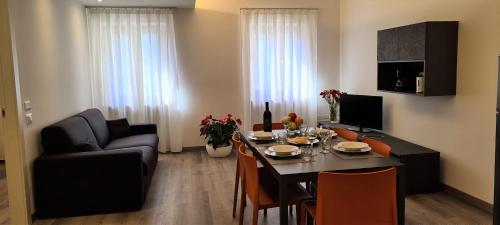 a living room with a dining room table and a couch at RivAppartamenti in Riva del Garda
