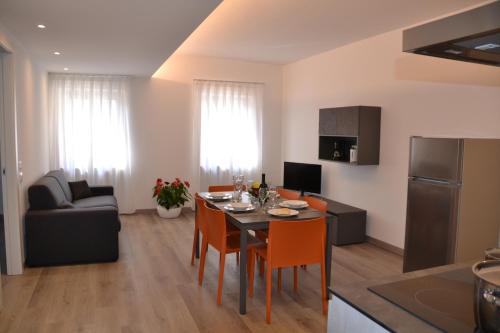 a kitchen and living room with a table and chairs at RivAppartamenti in Riva del Garda
