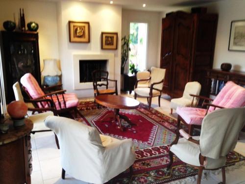 sala de estar con sillas, mesa y chimenea en Villa Orion, en Capbreton