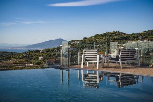 duas cadeiras sentadas à beira de uma piscina em Agriresort Villa Edera em Massa Lubrense