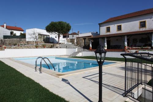 a swimming pool in the yard of a house at Casa de Santo Antonio in Mortágua