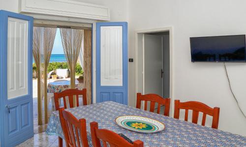 comedor con mesa y vistas al océano en Villetta Maredorat Vista Mare by HDSalento, en Torre Vado