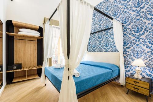 a bedroom with a bed with blue and white wallpaper at Incao Holiday I Pupi House in Cefalù