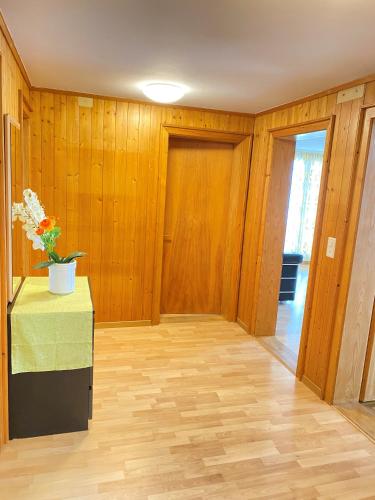 a room with wooden walls and a table with flowers on it at Brienzersee - Direct lake view in Brienz