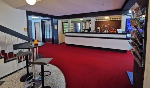 a lobby with a red carpet and a bar at Hotel Grille in Erlangen
