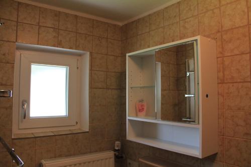 a bathroom with a medicine cabinet and a mirror at Ferienhaus Landsberg Am Lech in Landsberg am Lech