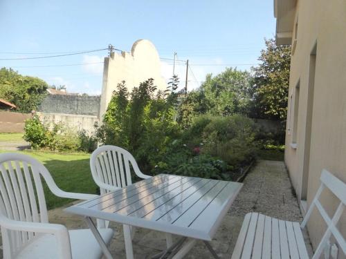 einen weißen Picknicktisch und zwei weiße Stühle auf einer Terrasse in der Unterkunft Villa Orion in Capbreton
