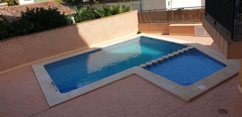 una piscina con agua azul en un patio trasero en FMM Apartamentos Magic Finestrat Benidorm Holidays, en Cala de Finestrat