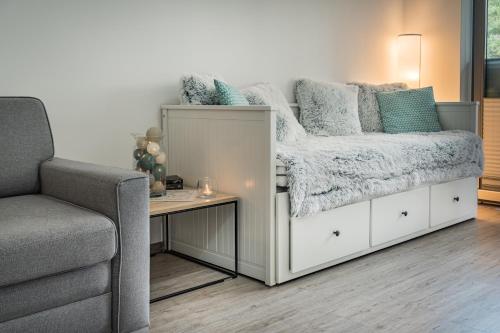a bed in a room with a couch and a table at KASANDRA in Pobierowo