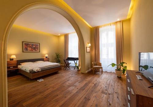 Un arco en un dormitorio con una cama y un escritorio. en Casa Nym, en Brasov
