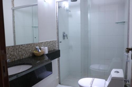 a bathroom with a shower and a sink and a toilet at Alfa Hotel Teresina in Teresina