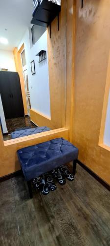 a blue bench in a room with shoes on the floor at Fantastic Place in Apatin