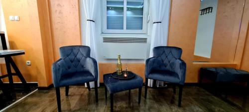 a room with blue chairs and a table and a window at Fantastic Place in Apatin