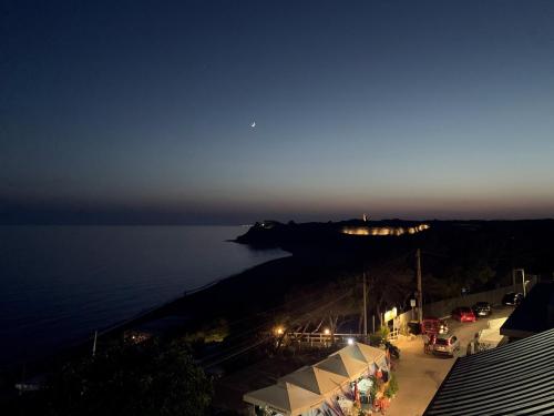 a view of the ocean at night with tents at La Rosa Hotel - Selinunte in Marinella di Selinunte