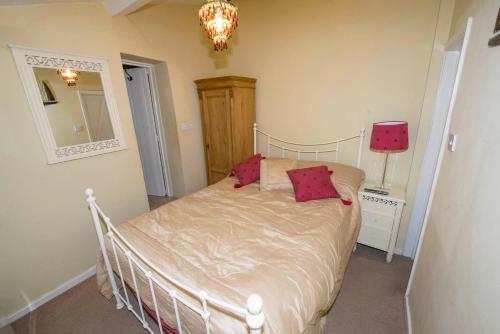 a bedroom with a bed and a mirror and a lamp at 1 bedroomed Cottage near quay in Blakeney