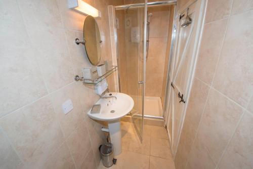 a bathroom with a sink and a shower at 1 bedroomed Cottage near quay in Blakeney
