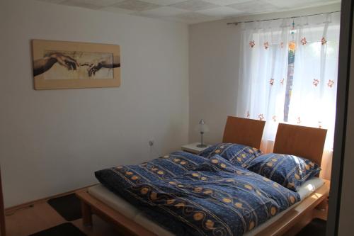 a bed with a blue comforter in a bedroom at Ferienhaus Landsberg Am Lech in Landsberg am Lech