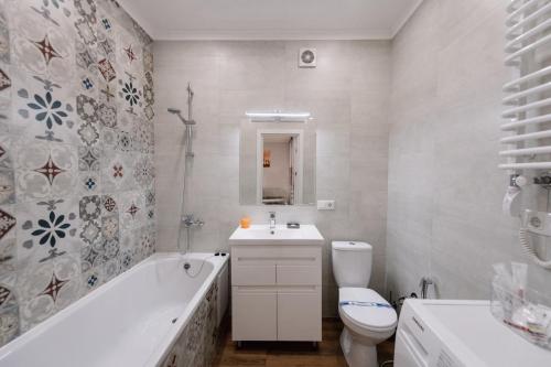 W łazience znajduje się toaleta, wanna i umywalka. w obiekcie Комфортна та тиха квартира у Центрі міста w mieście Tarnopol