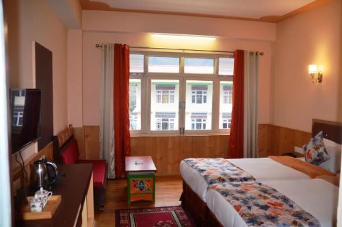 a hotel room with a bed and a window at Le Coxy Resort Lachung in Lachung