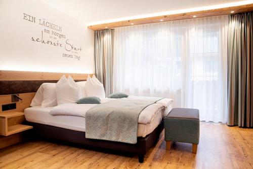 a bedroom with a large bed and a large window at Hotel Hemizeus & Iremia Spa in Zermatt