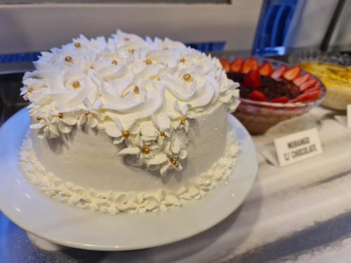 a white cake on a plate on a table at Hotel Appel in Santa Maria