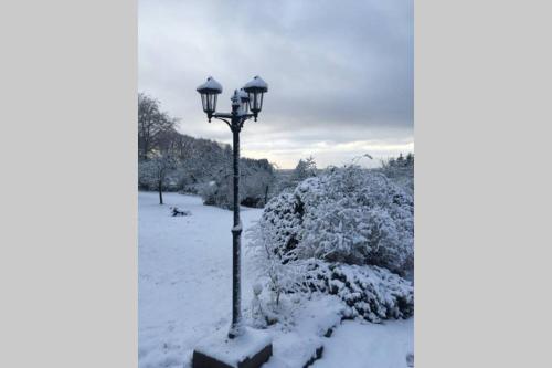 a light pole with snow on it in a park at The Bakery in Beauficel