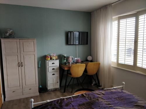 a bedroom with a desk and a table and a bed at El Puerto Bed and Breakfast in Hoorn