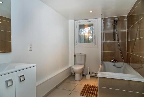 a bathroom with a toilet and a tub and a sink at Villa Le Menez Avec Vue Sur Le Lac Marin Pour 10 Personnes in Hossegor