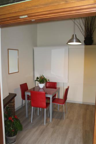a dining room with a table and red chairs at Hotel Il Casale in Trevignano Romano