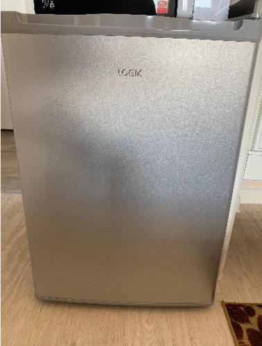 a gray refrigerator sitting on a wooden floor at Quiet, spacious double bedroom! in Peterborough
