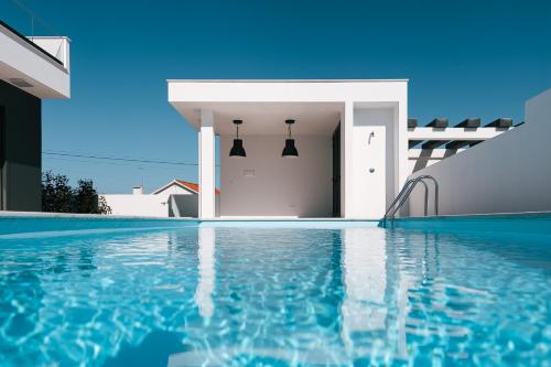 a swimming pool in front of a house at Villa Chaves in Óbidos