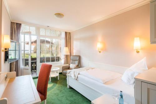 a hotel room with a bed and a desk at Romantik Hotel Jagdhaus Eiden am See in Bad Zwischenahn