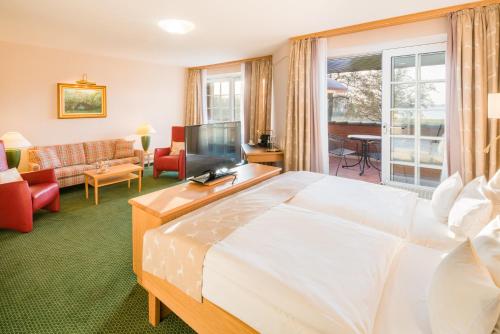 a hotel room with a large bed and a living room at Romantik Hotel Jagdhaus Eiden am See in Bad Zwischenahn