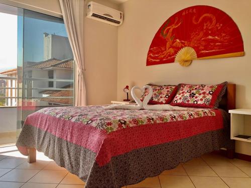 a bedroom with a bed and a large window at Kasato Maru Residence 100 mts do mar ingleses norte in Florianópolis