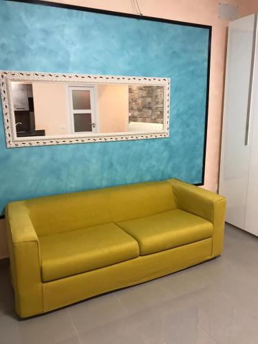 a yellow couch in front of a wall with a mirror at Guest House Bracciano RM in Bracciano