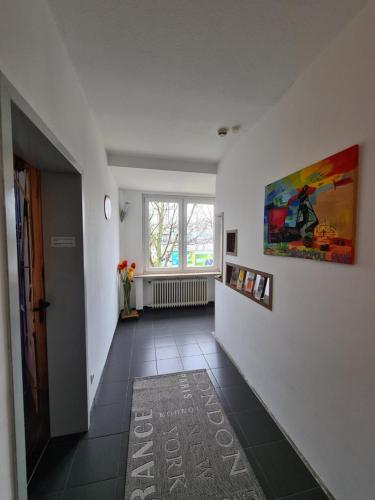 a hallway with white walls and a painting on the wall at Hotel Aleo in Bochum