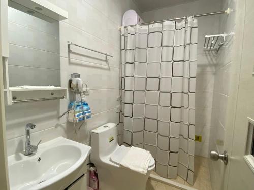 金沙鎮的住宿－立姐咖啡民宿，白色的浴室设有卫生间和水槽。