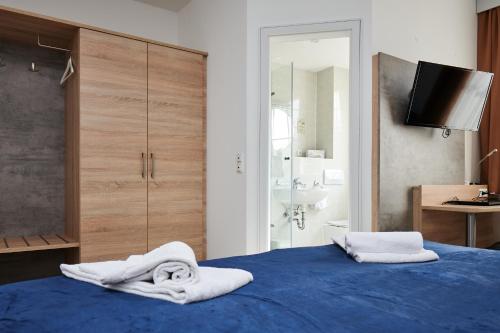Un dormitorio con una cama azul con toallas. en Zur Allacher Mühle, en Múnich
