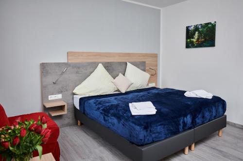 1 dormitorio con 1 cama y 1 silla roja en Zur Allacher Mühle, en Múnich