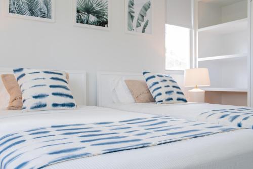 um quarto com 2 camas com almofadas azuis e brancas em Garden Grove em Saint James